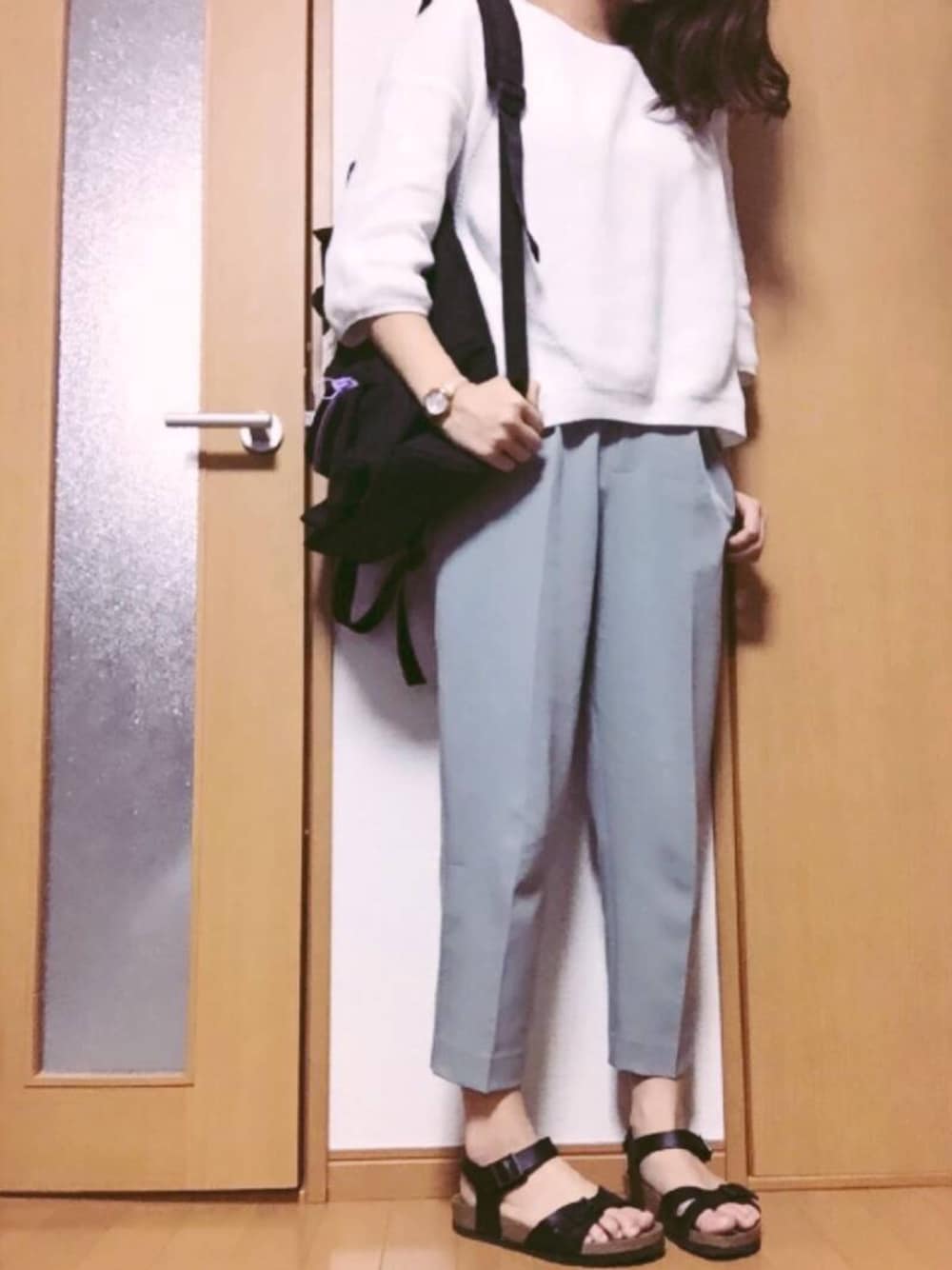 グレー系のその他パンツ、ホワイト系のニット/セーター、ブラック系のバックパック/リュックを着用したレディースの春コーディネートの1枚目の写真