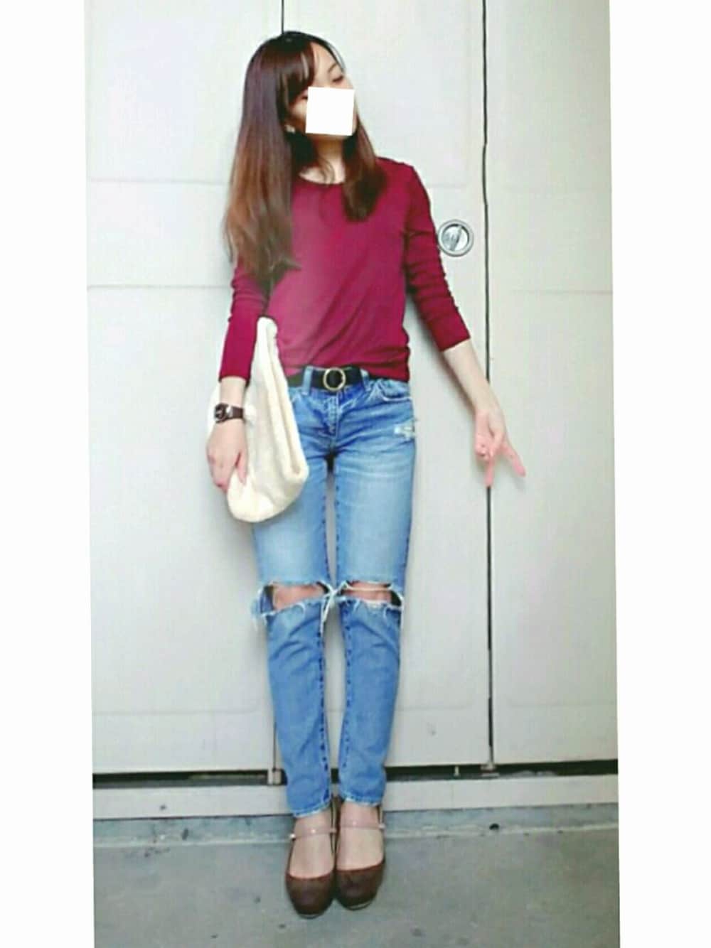 レッド系のTシャツ/カットソー、ホワイト系のクラッチバッグ、ブルー系のデニムパンツを着用したレディースの秋コーディネートの1枚目の写真