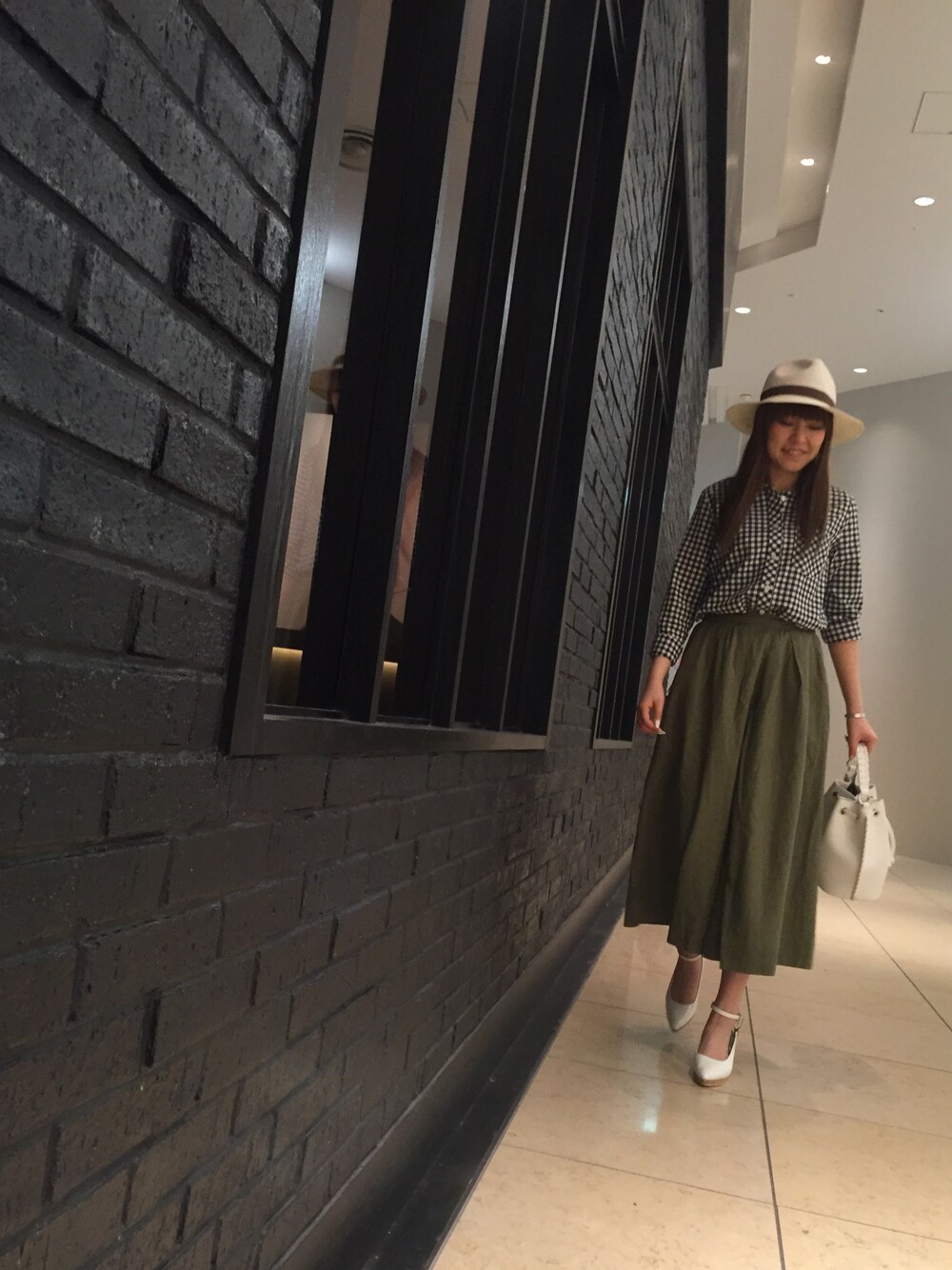 ホワイト系のパンプス、ホワイト系のショルダーバッグを着用したレディースの春コーディネートの1枚目の写真