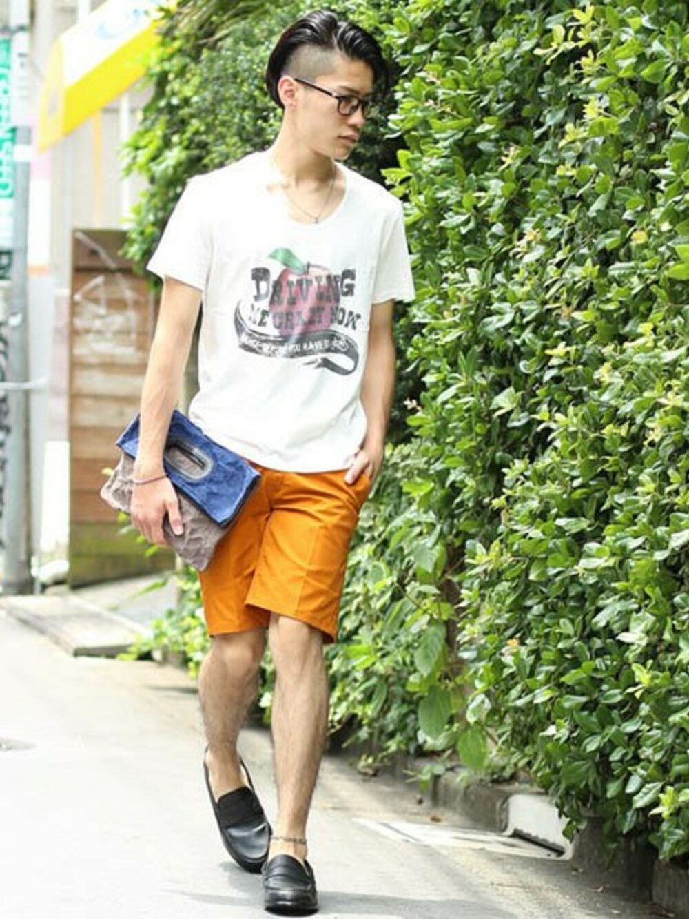 ホワイト系のTシャツ/カットソー、オレンジ系のチノパンツ、グレー系のクラッチバッグを着用したメンズの夏コーディネートの1枚目の写真