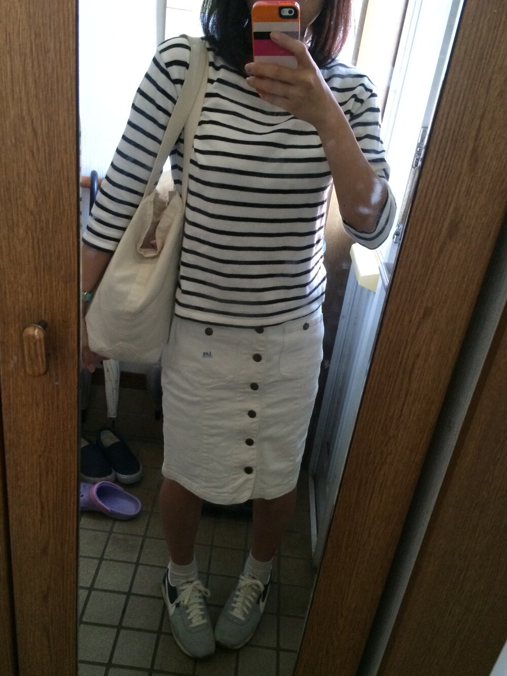 ホワイト系のTシャツ/カットソー、ホワイト系のスカート、その他のトートバッグを着用したレディースの秋コーディネートの1枚目の写真