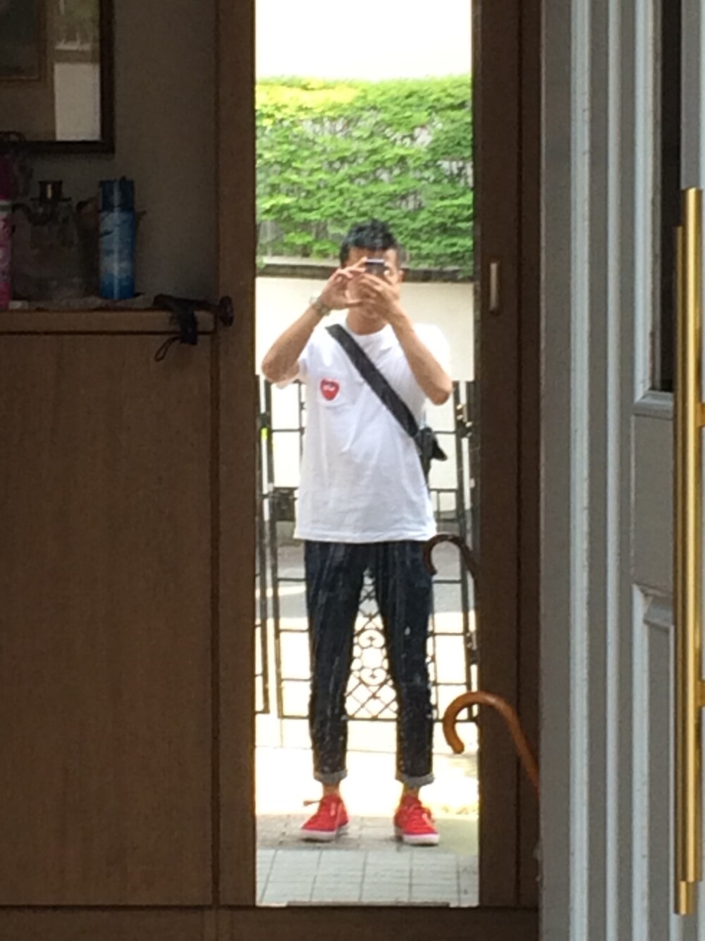 ホワイト系のTシャツ/カットソー、ブルー系のデニムパンツ、レッド系のスニーカーを着用したメンズの春コーディネートの1枚目の写真