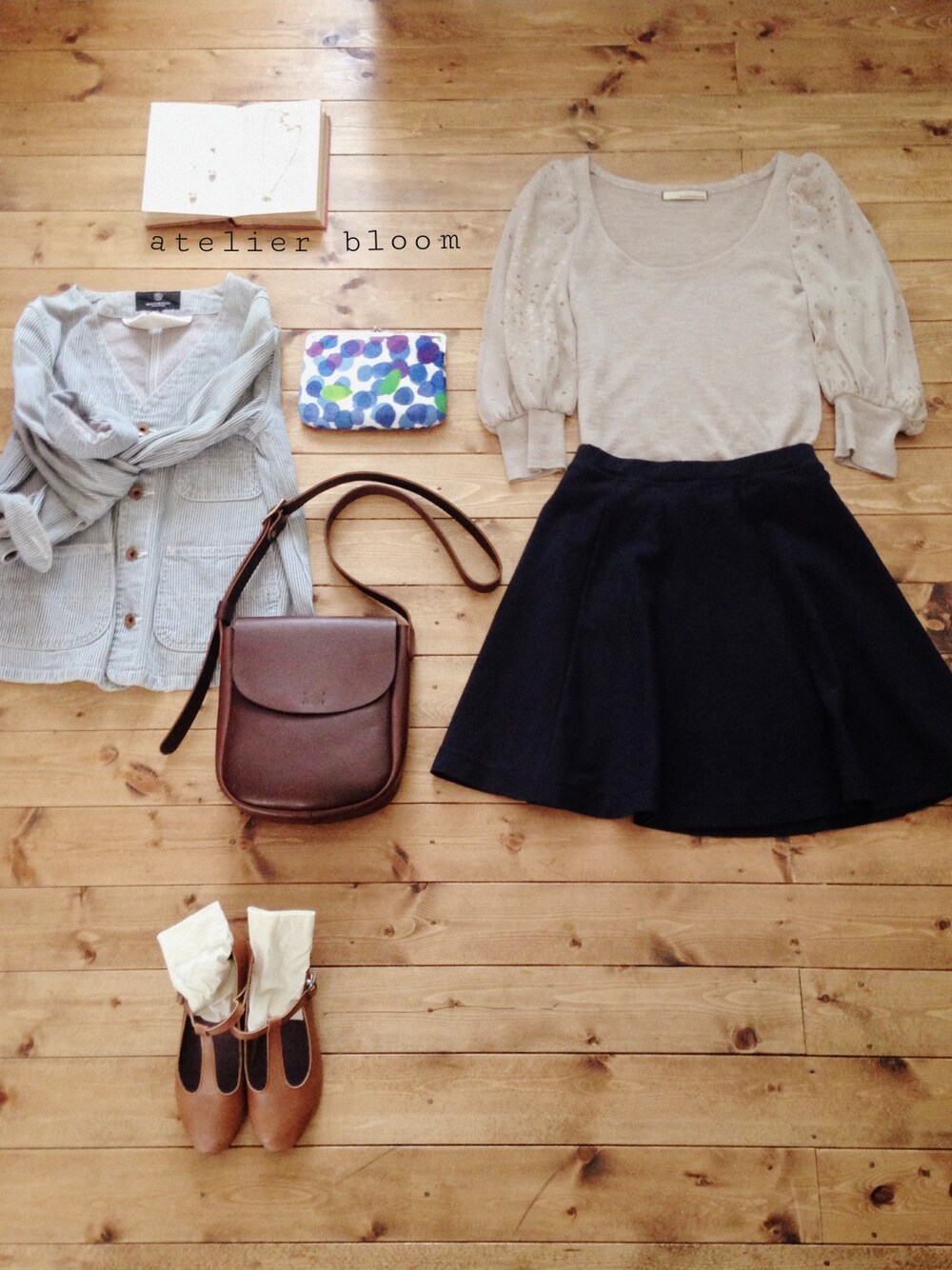 ブルー系のスカート、ホワイト系のピアス(両耳用)、ゴールド系のネックレスを着用したレディースの春コーディネートの1枚目の写真