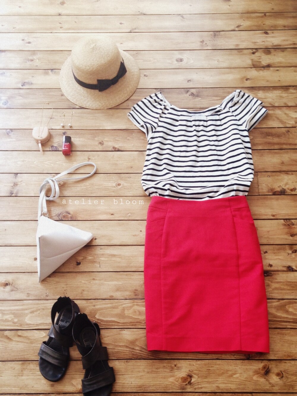 ホワイト系のクラッチバッグ、ゴールド系のネックレス、ホワイト系のピアス(両耳用)を着用したレディースの春コーディネートの1枚目の写真