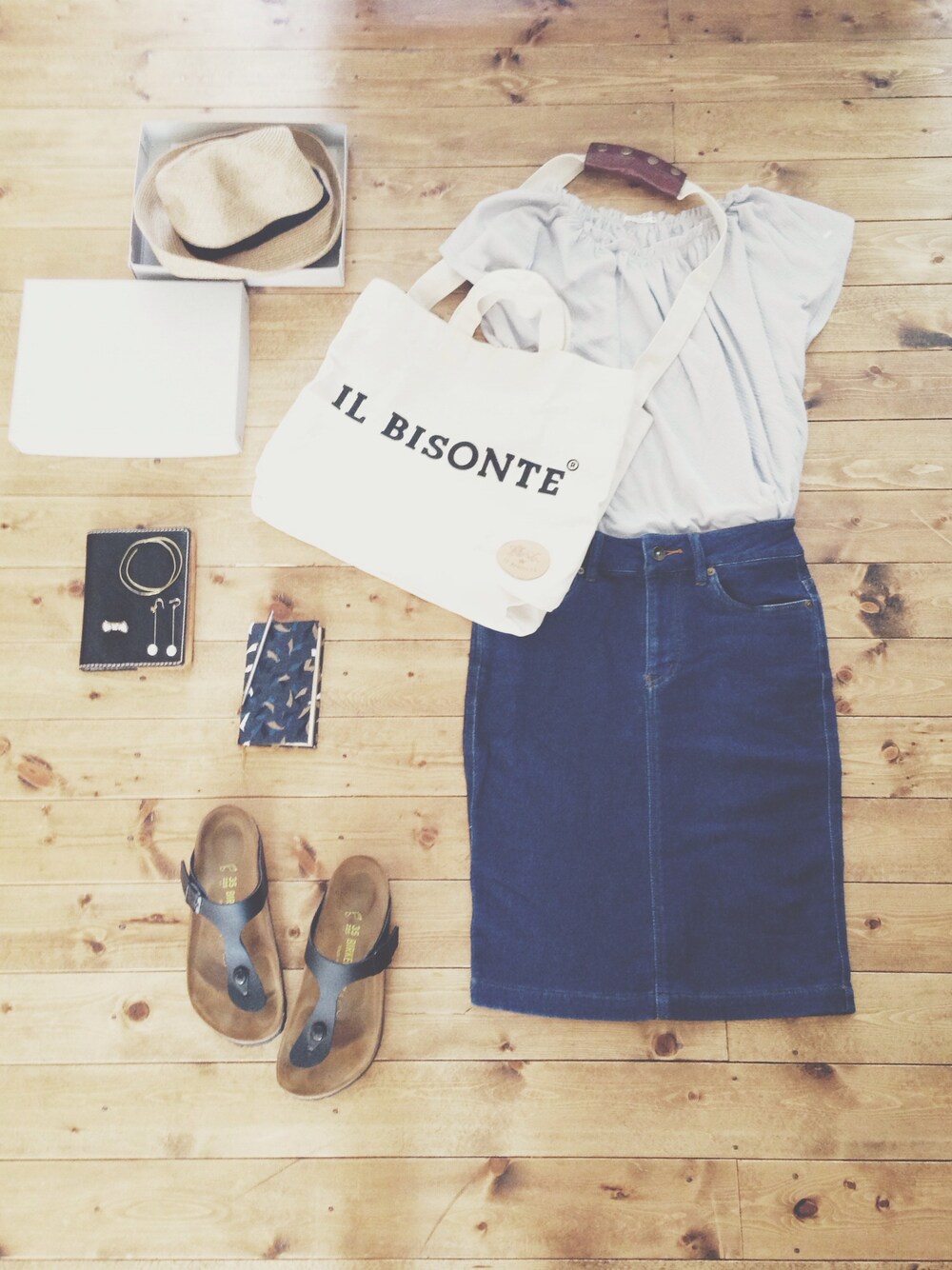 ホワイト系のトートバッグ、ブルー系のTシャツ/カットソー、ブルー系のデニムスカートを着用したレディースの夏コーディネートの1枚目の写真