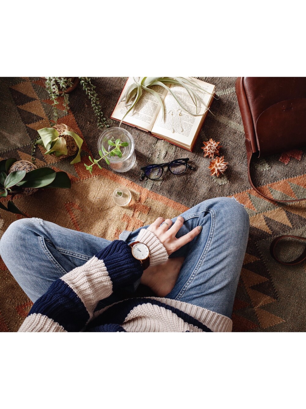 ブルー系のニット/セーター、ブラウン系のショルダーバッグ、ブルー系のデニムパンツを着用したレディースの冬コーディネートの1枚目の写真