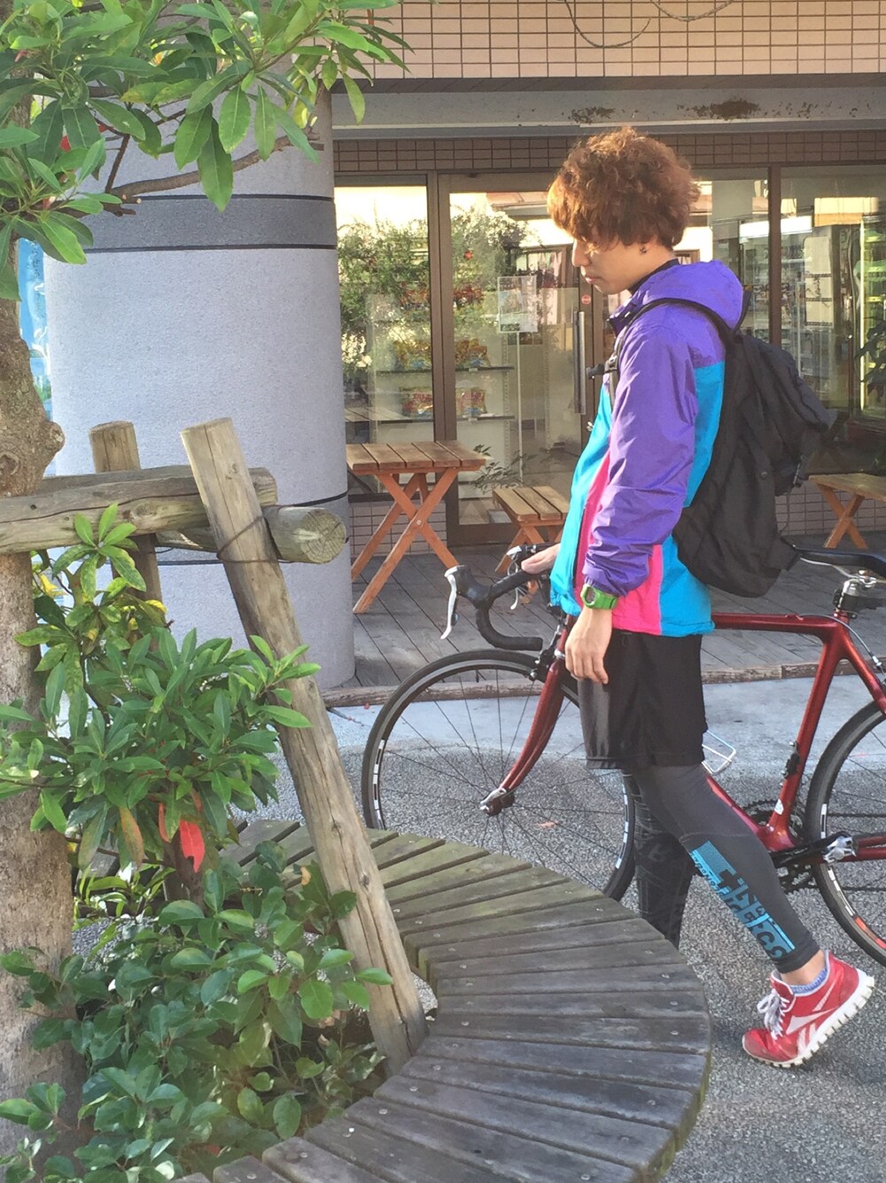 パープル系のマウンテンパーカー、ブラック系のバックパック/リュック、レッド系のシューズを着用したメンズの秋コーディネートの1枚目の写真