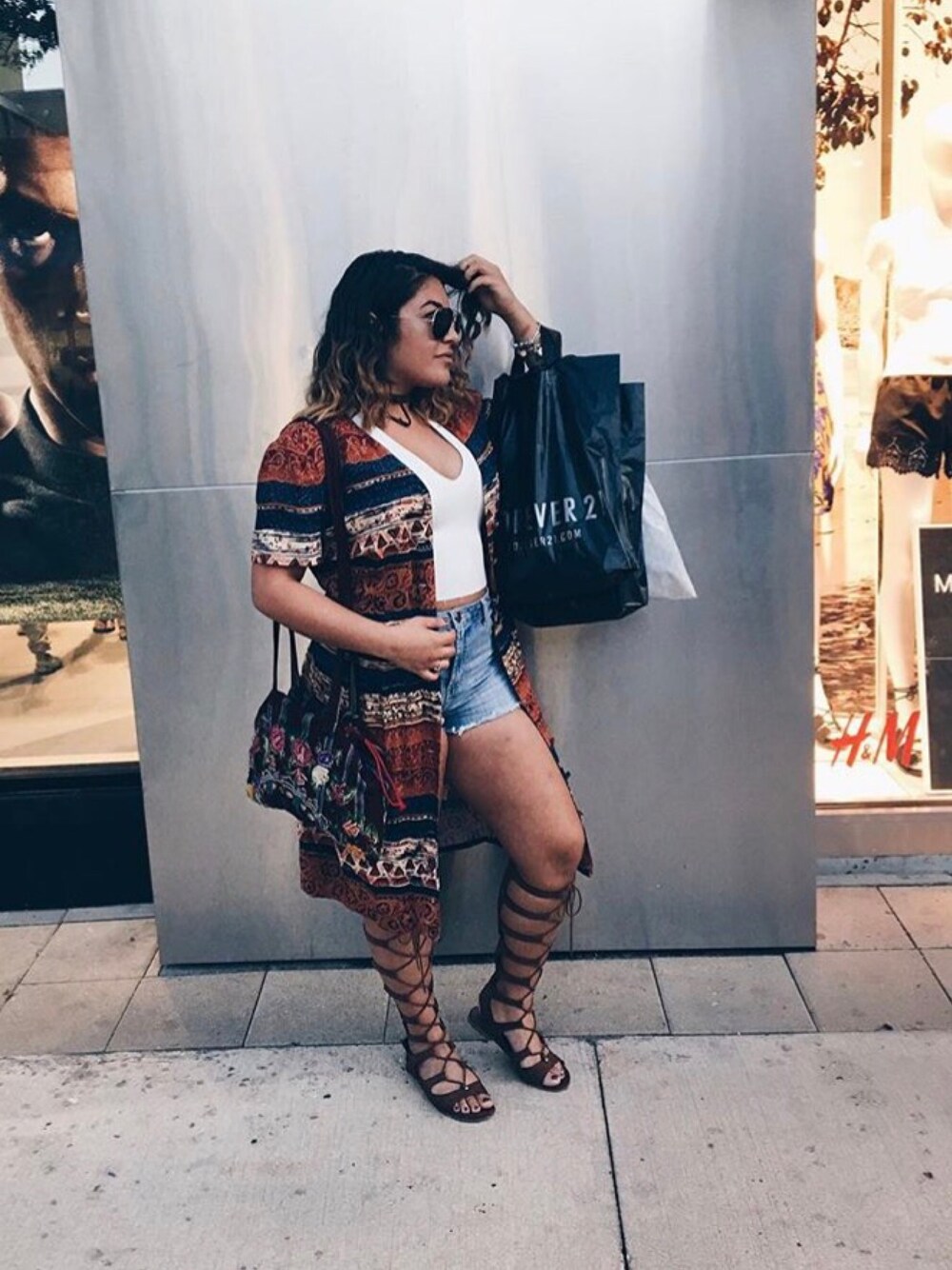 ホワイト系のタンクトップ、ブルー系のデニムパンツ、ブラウン系のサンダルを着用したレディースの秋コーディネートの1枚目の写真