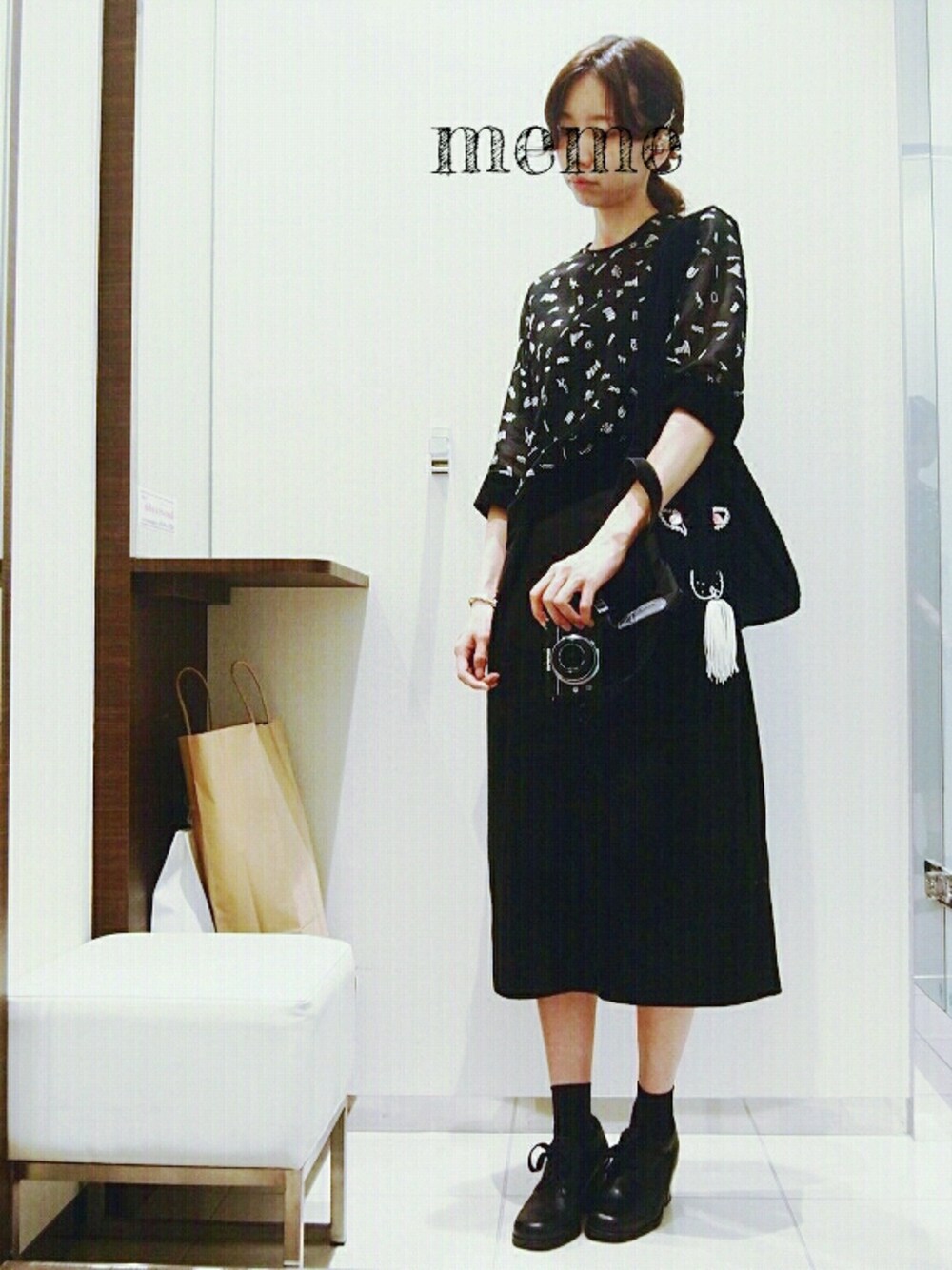 ブラック系のスカート、ブラック系のトップス、ブルー系のショルダーバッグを着用したレディースの秋コーディネートの1枚目の写真