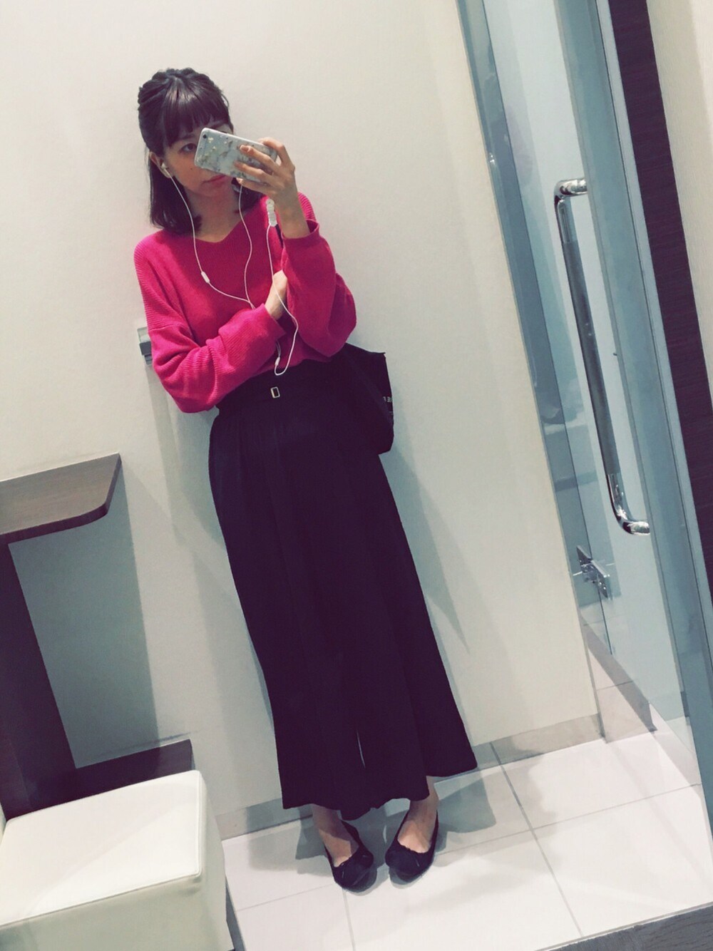 ピンク系のニット/セーター、ブラック系のショルダーバッグ、ブラック系のパンツを着用したレディースの秋コーディネートの1枚目の写真