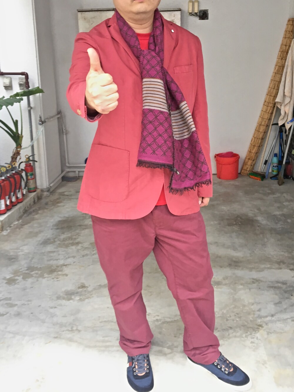 レッド系のジャケット/アウター、レッド系のチノパンツ、ブルー系のスニーカーを着用したメンズの冬コーディネートの1枚目の写真