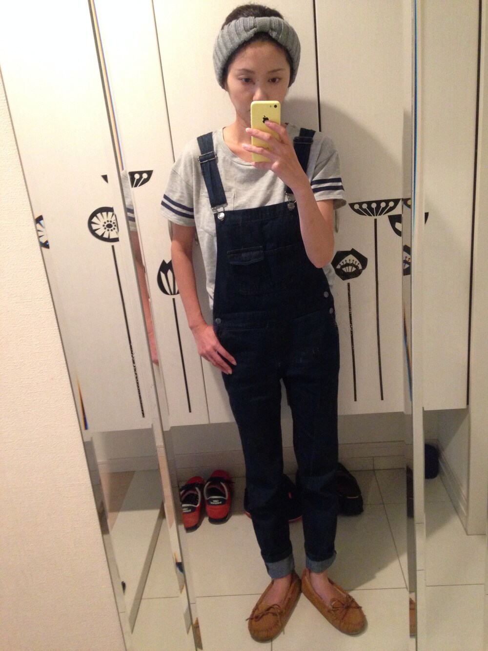 ブルー系のサロペット/オーバーオール、イエロー系のモカシン/デッキシューズ、グレー系のTシャツ/カットソーを着用したレディースの秋コーディネートの1枚目の写真