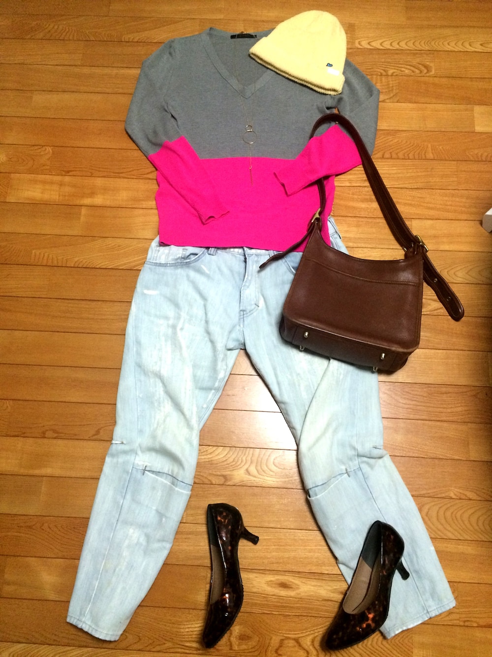 グレー系のニット/セーター、ブルー系のデニムパンツ、ブラウン系のショルダーバッグを着用したレディースの春コーディネートの1枚目の写真