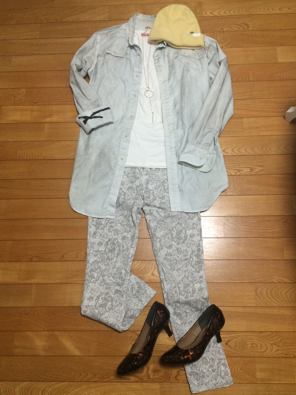 グレー系のシャツ/ブラウス、ブラウン系のパンプス、イエロー系のニットキャップ/ビーニーを着用したレディースの春コーディネートの1枚目の写真