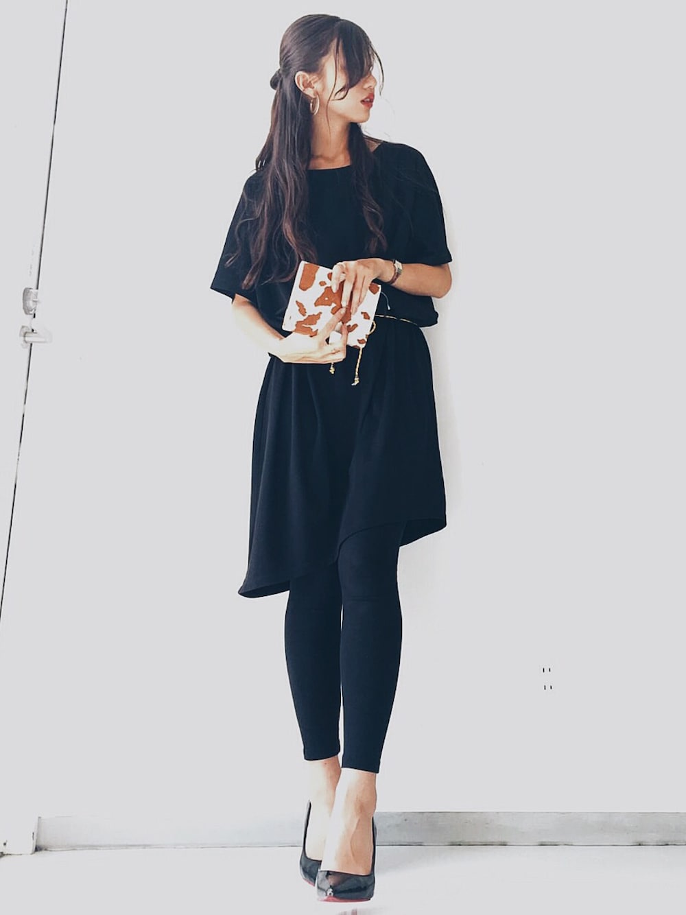 ブラック系のワンピース、ブラック系のパンプス、ブラック系のレギンス/スパッツを着用したレディースの秋コーディネートの1枚目の写真