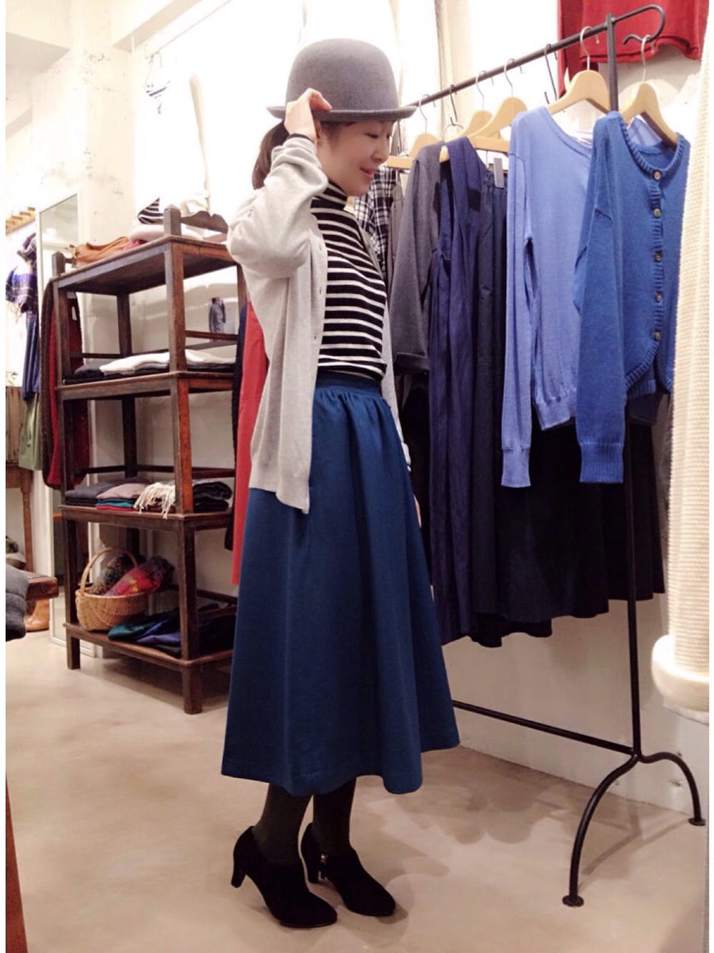 グリーン系のスカート、ブラック系のTシャツ/カットソー、グリーン系のカーディガン/ボレロを着用したレディースの秋コーディネートの1枚目の写真