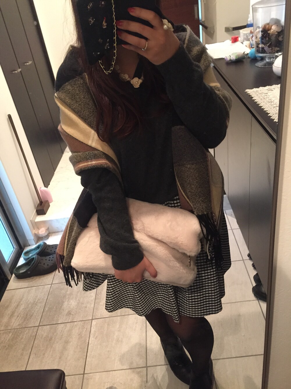 ブラック系のブーツ、ホワイト系のクラッチバッグ、ホワイト系のスカートを着用したレディースの秋コーディネートの1枚目の写真