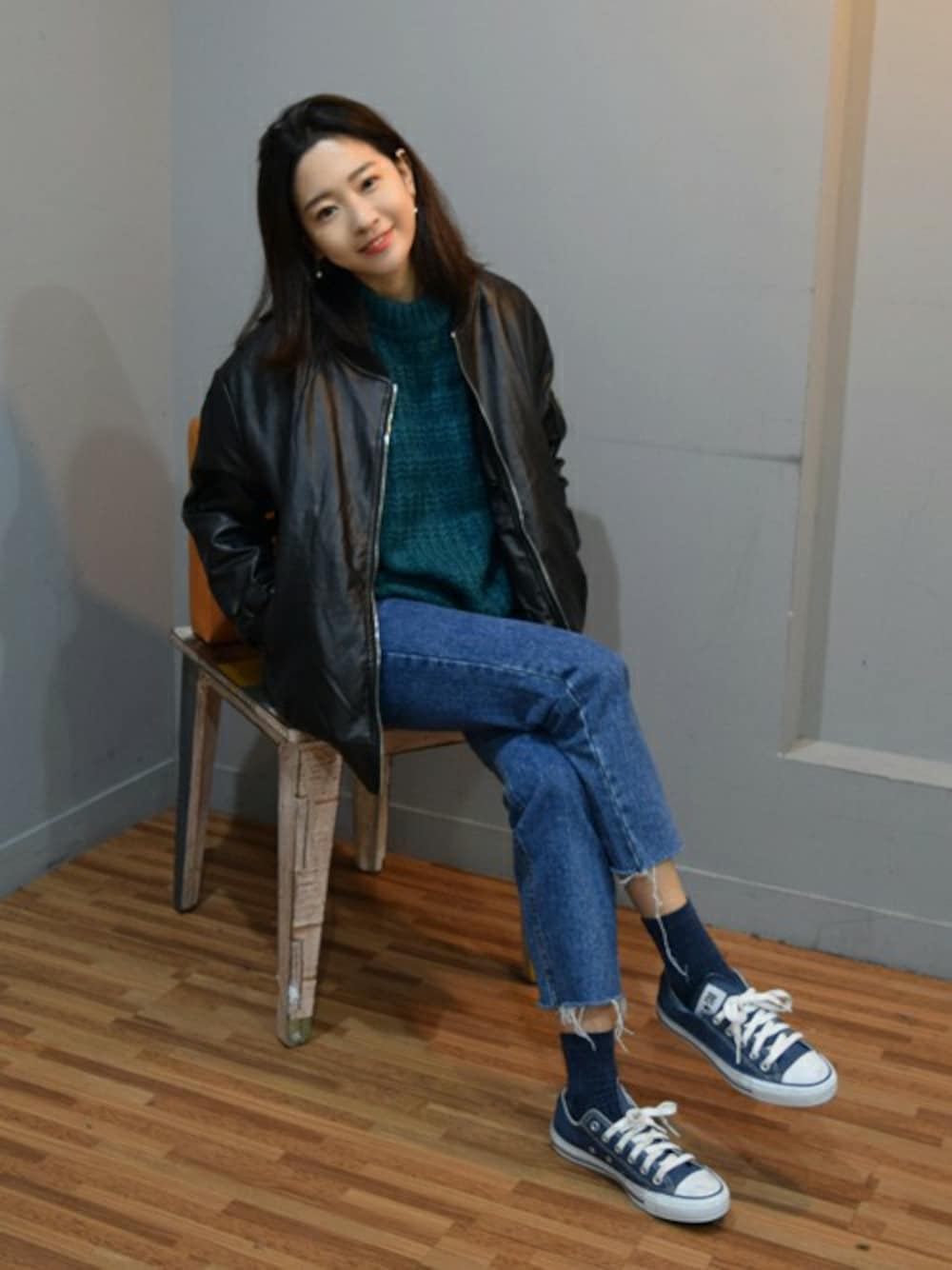 ブラック系のスタジャン、ブルー系のデニムパンツを着用したレディースの秋コーディネートの1枚目の写真