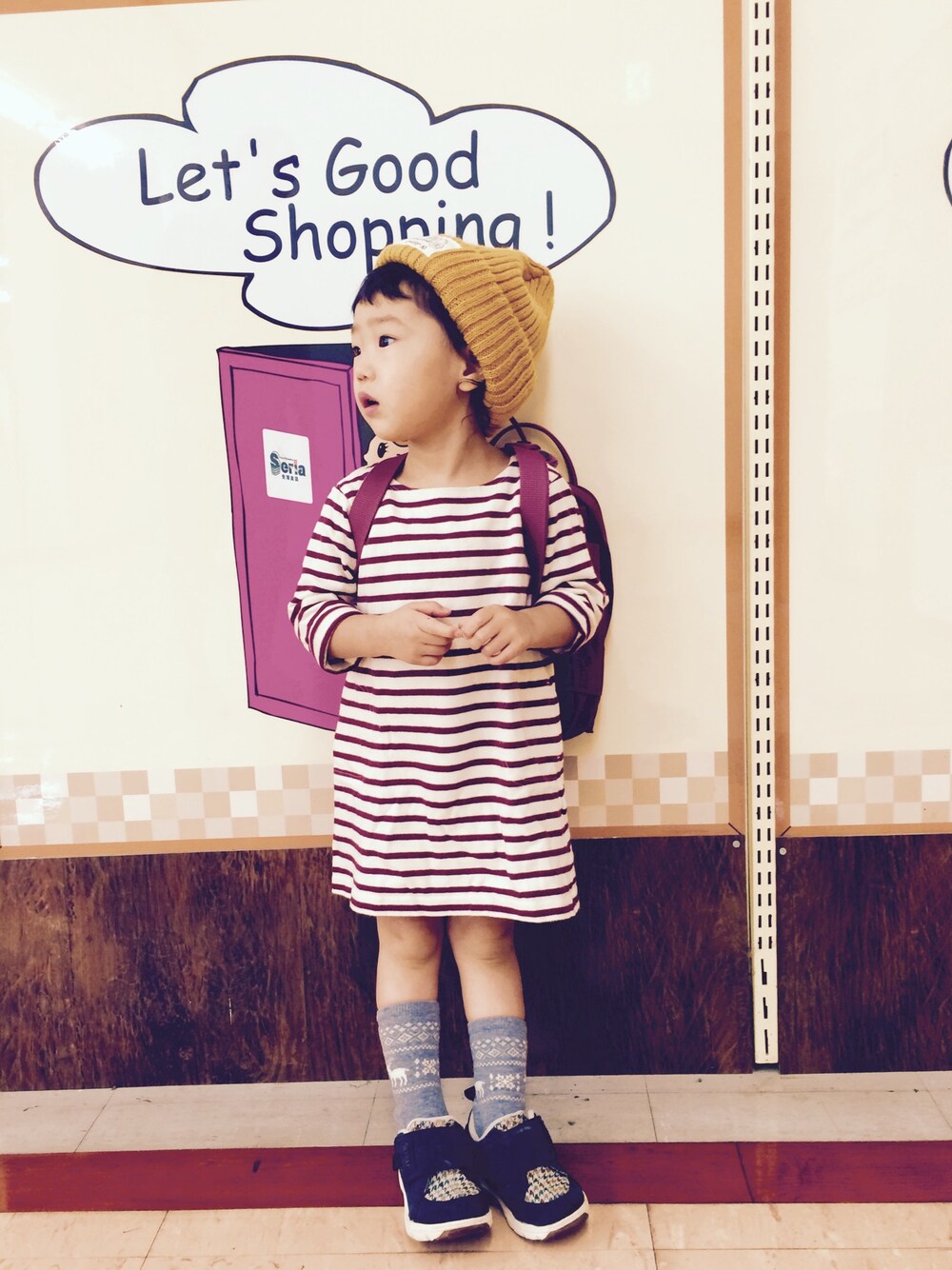 レッド系のワンピース、ブラック系のスニーカー、レッド系のバックパック/リュックを着用したキッズの秋コーディネートの1枚目の写真