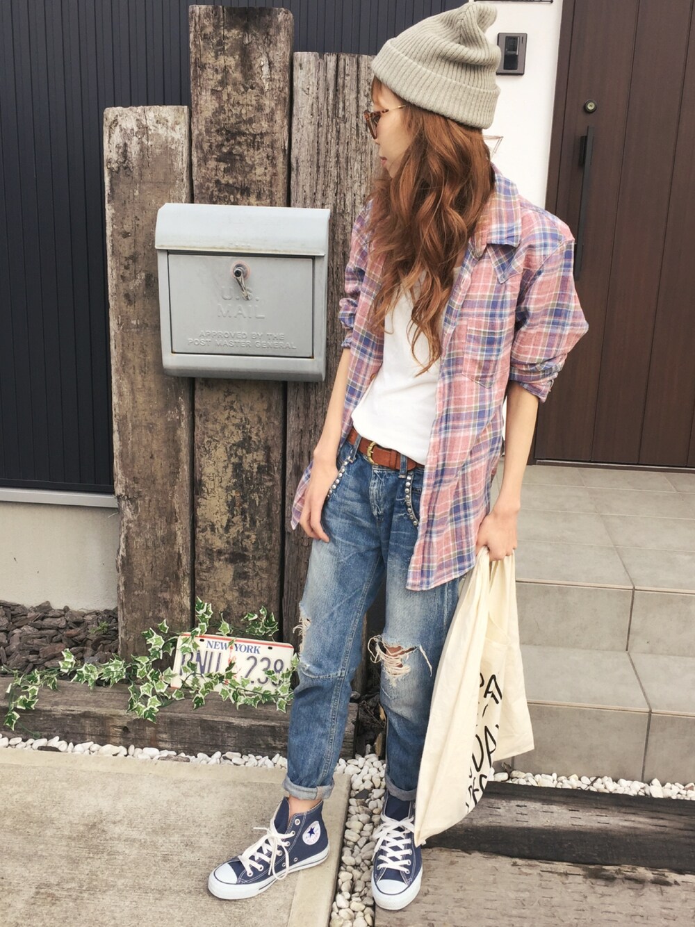 ブルー系のデニムパンツ、ピンク系のシャツ/ブラウス、ブルー系のスニーカーを着用したレディースの春コーディネートの1枚目の写真