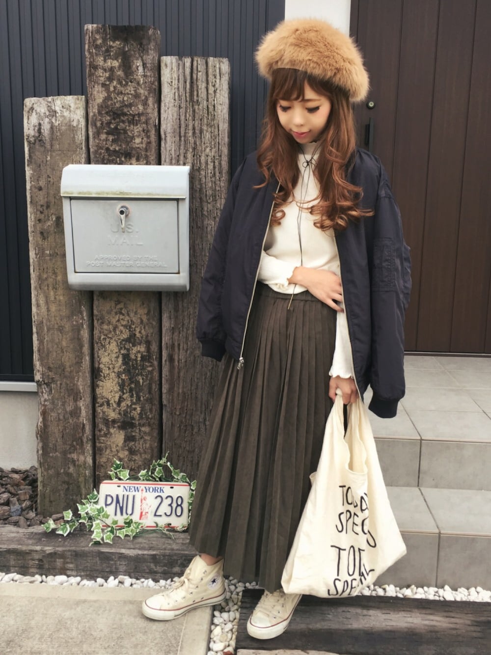 ホワイト系のトップス、ブラック系のジャケット/アウター、グリーン系のスカートを着用したレディースの秋コーディネートの1枚目の写真