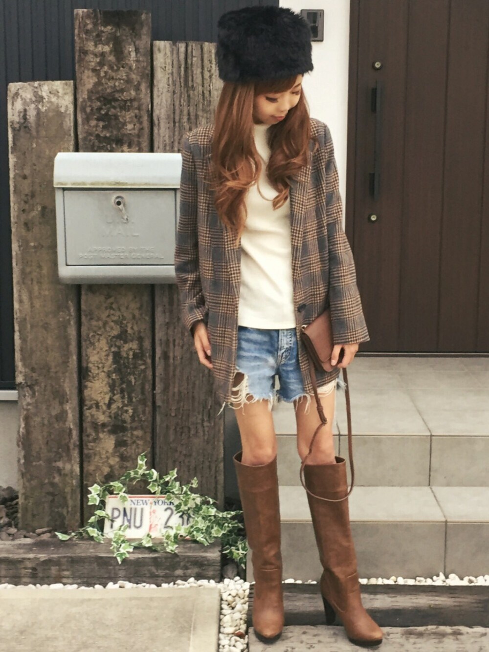 ブラウン系のテーラードジャケット、ホワイト系のトップス、ブルー系のデニムパンツを着用したレディースの秋コーディネートの1枚目の写真