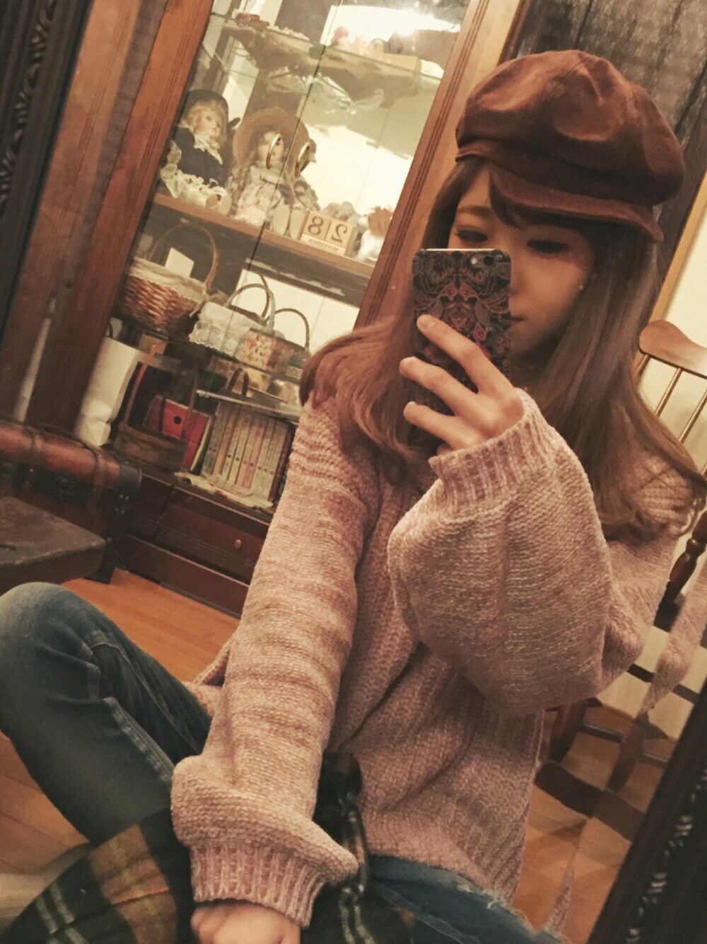 ブルー系のデニムパンツ、ピンク系のニット/セーター、ブラウン系のキャスケットを着用したレディースの冬コーディネートの1枚目の写真