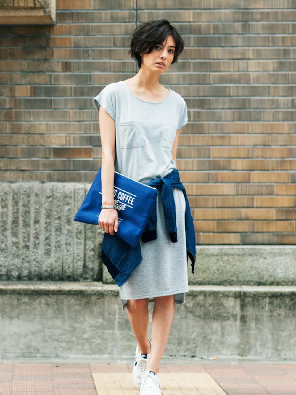 グレー系のワンピース、ブルー系のデニムジャケットを着用したレディースの夏コーディネートの1枚目の写真