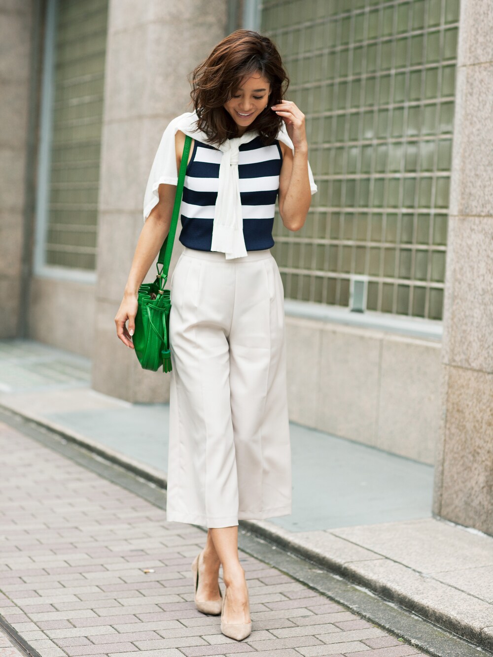 ブルー系のタンクトップ、ベージュ系のその他パンツ、ゴールド系のピアス(両耳用)を着用したレディースの夏コーディネートの1枚目の写真