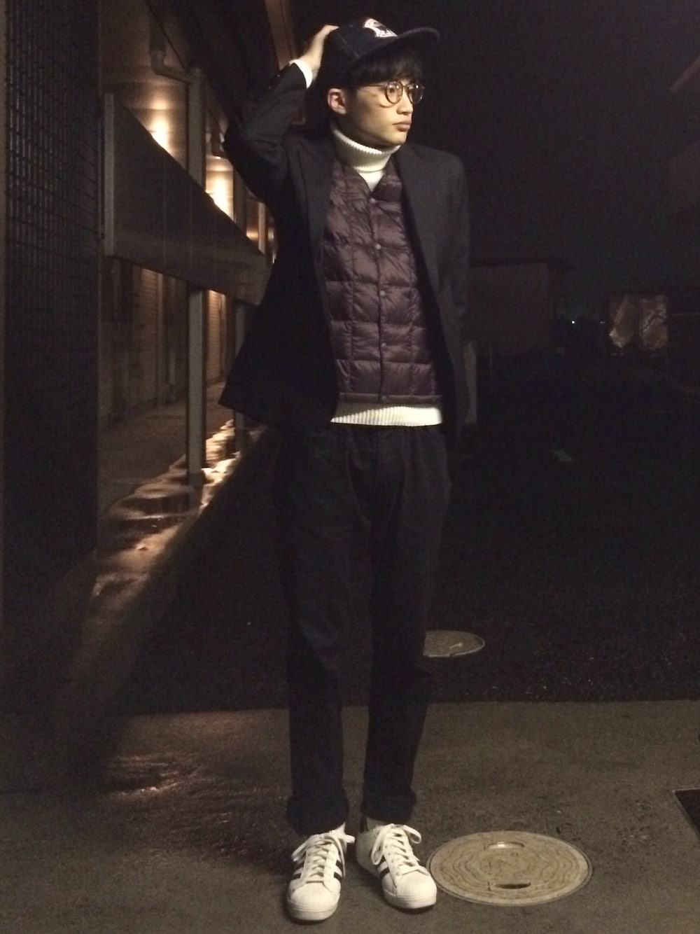 ブラック系のテーラードジャケット、レッド系のダウンベスト、ホワイト系のニット/セーターを着用したメンズの冬コーディネートの1枚目の写真