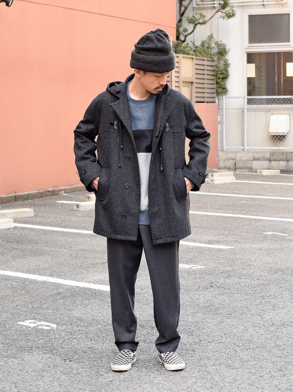 ブラック系のダッフルコート、グレー系のその他パンツ、ブルー系のニット/セーターを着用したメンズの秋コーディネートの1枚目の写真