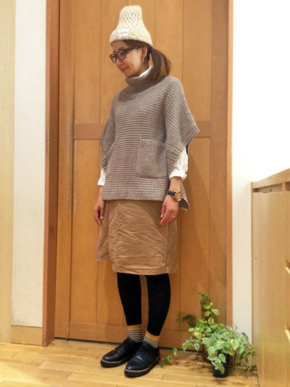 ベージュ系のニット/セーター、ブラウン系のスカート、ホワイト系のシャツ/ブラウスを着用したレディースの秋コーディネートの1枚目の写真