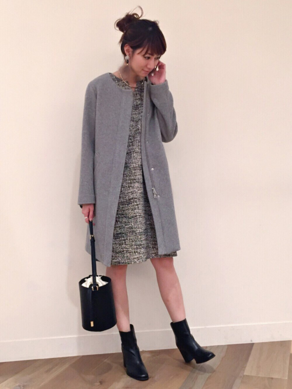 グレー系のチェスターコート、ブラック系のショルダーバッグ、ブラック系のシューズを着用したレディースの秋コーディネートの1枚目の写真