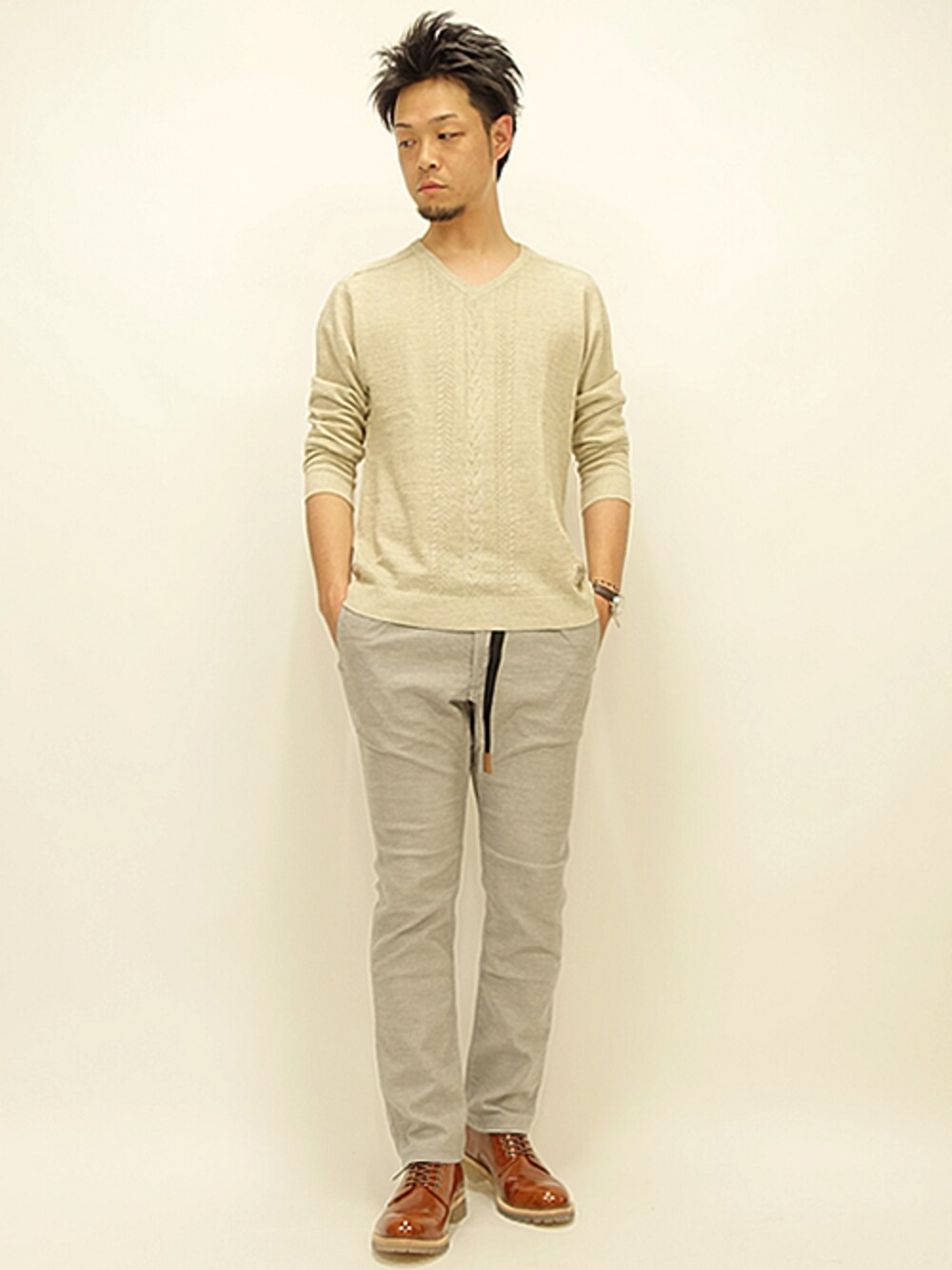 ベージュ系のニット/セーター、グレー系のその他パンツ、ブラウン系のドレスシューズを着用したメンズの春コーディネートの1枚目の写真