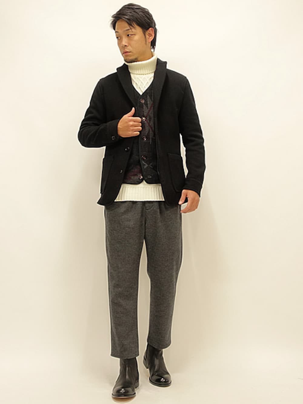 ブラック系のミリタリージャケット、ブラック系のベスト、ホワイト系のニット/セーターを着用したメンズの秋コーディネートの1枚目の写真