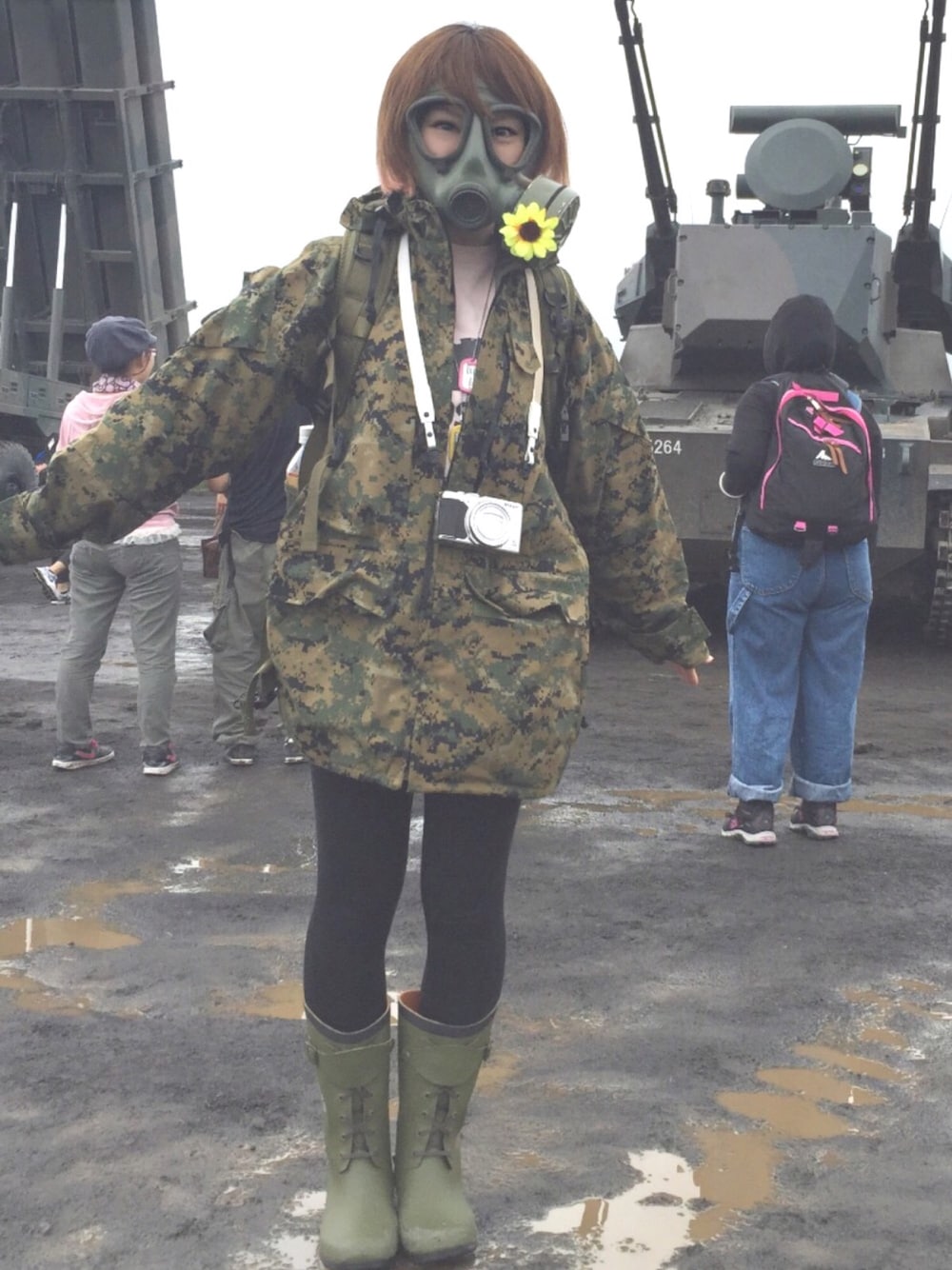 グリーン系のナイロンジャケット、グリーン系のレインシューズ、グリーン系のバックパック/リュックを着用したレディースの夏コーディネートの1枚目の写真