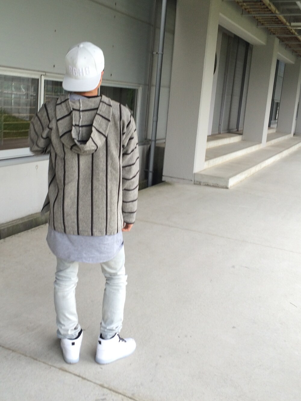 グレー系のパーカー、グレー系のTシャツ/カットソー、ブラック系のダウンジャケット/コートを着用したメンズの春コーディネートの1枚目の写真