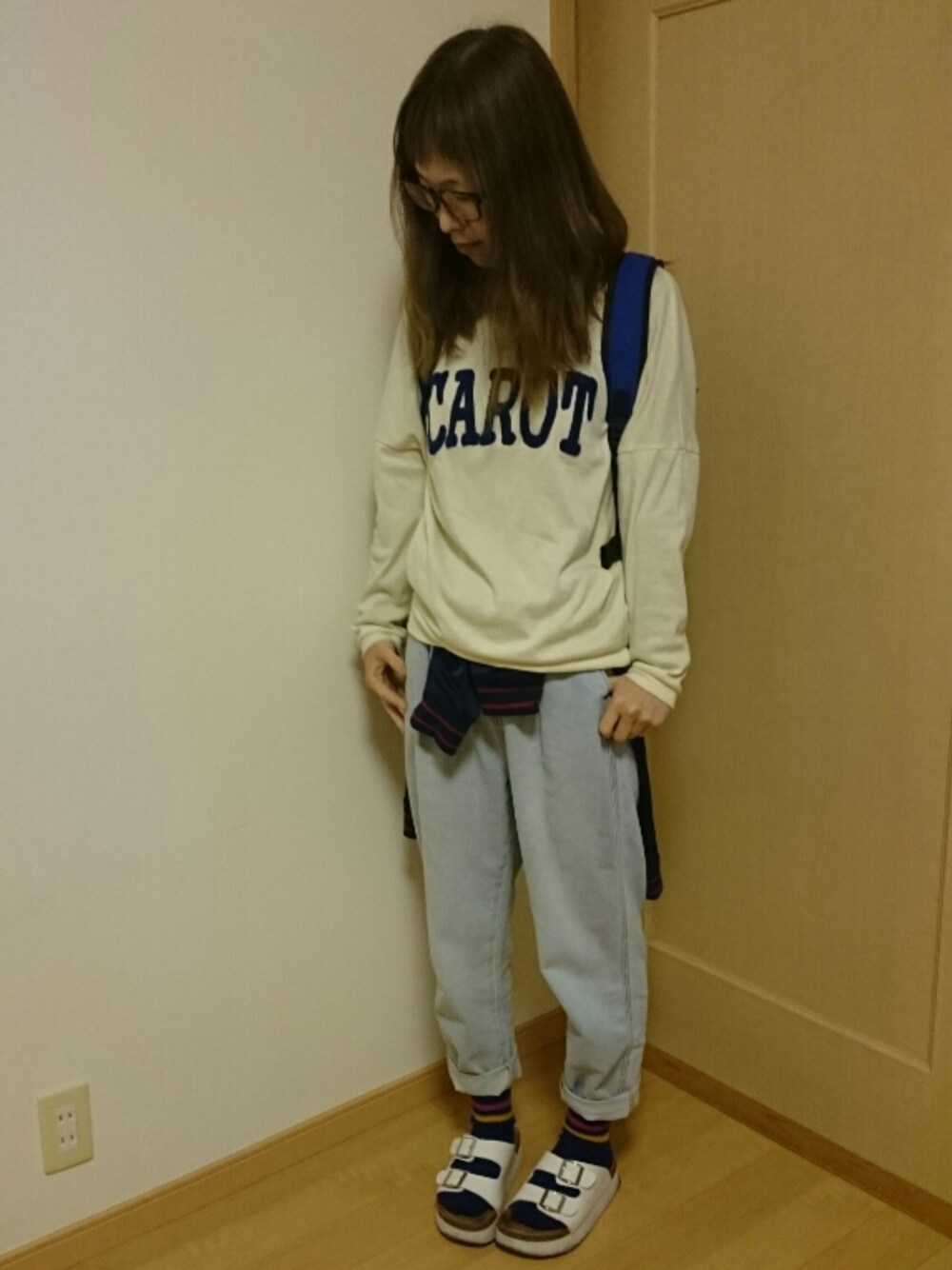 ブルー系のパンツ、ホワイト系のサンダル、ブルー系のバックパック/リュックを着用したレディースの春コーディネートの1枚目の写真