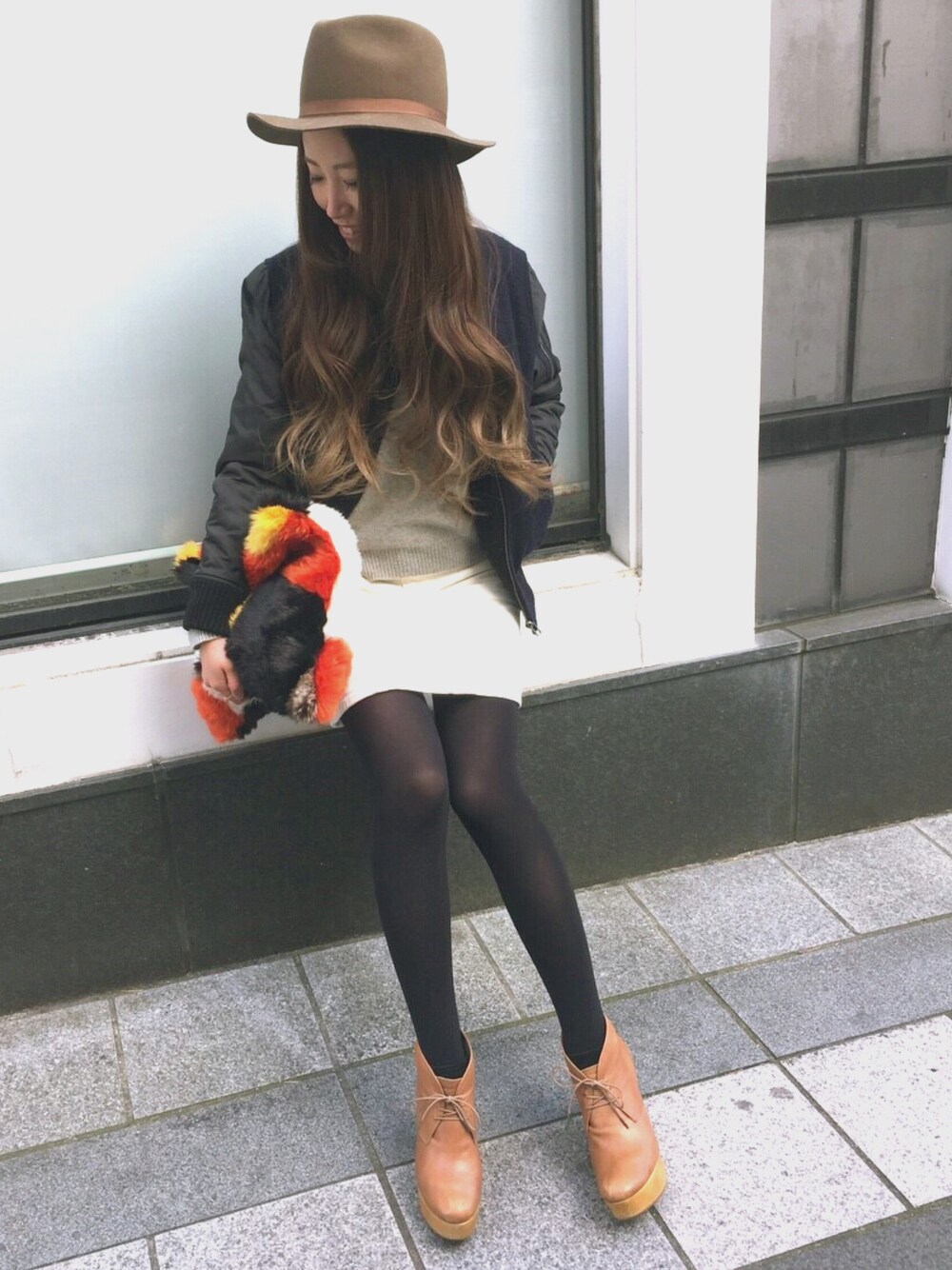 ブルー系のブルゾン、その他のクラッチバッグ、ホワイト系のスカートを着用したレディースの冬コーディネートの1枚目の写真