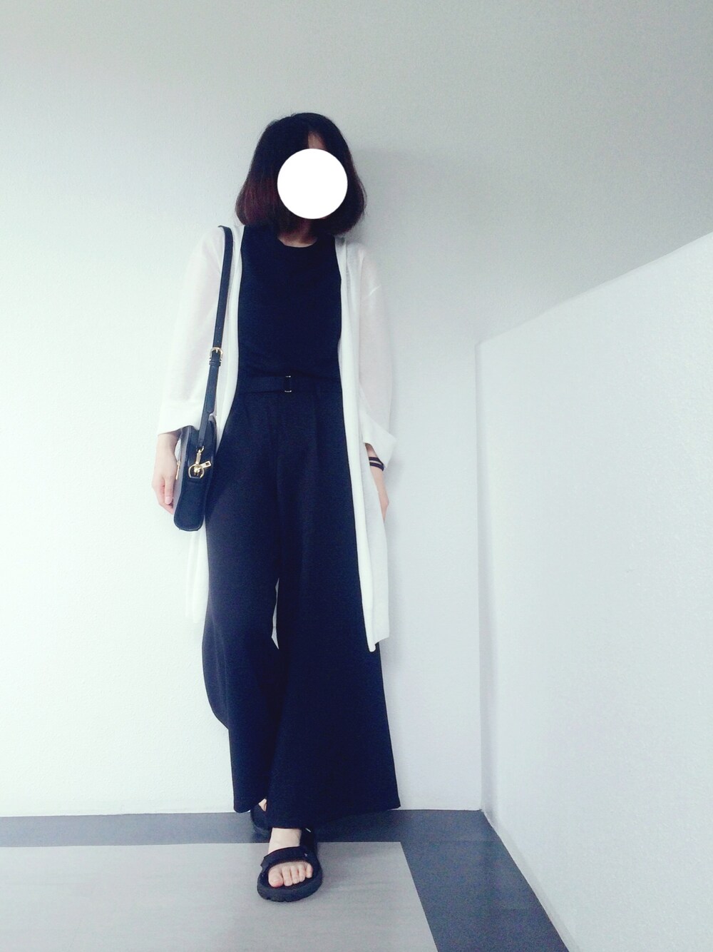 ホワイト系のカーディガン/ボレロ、ブラック系のタンクトップ、ブラック系のクラッチバッグを着用したレディースの夏コーディネートの1枚目の写真