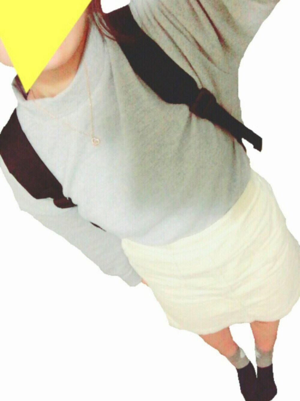 グレー系のトップス、ホワイト系のスカート、ブラック系のバックパック/リュックを着用したレディースの冬コーディネートの1枚目の写真