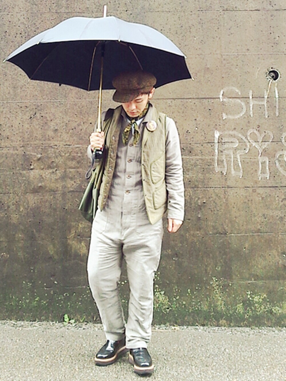 ブラウン系のつなぎ/オールインワン、グリーン系のベスト、グリーン系のトートバッグを着用したメンズの春コーディネートの1枚目の写真