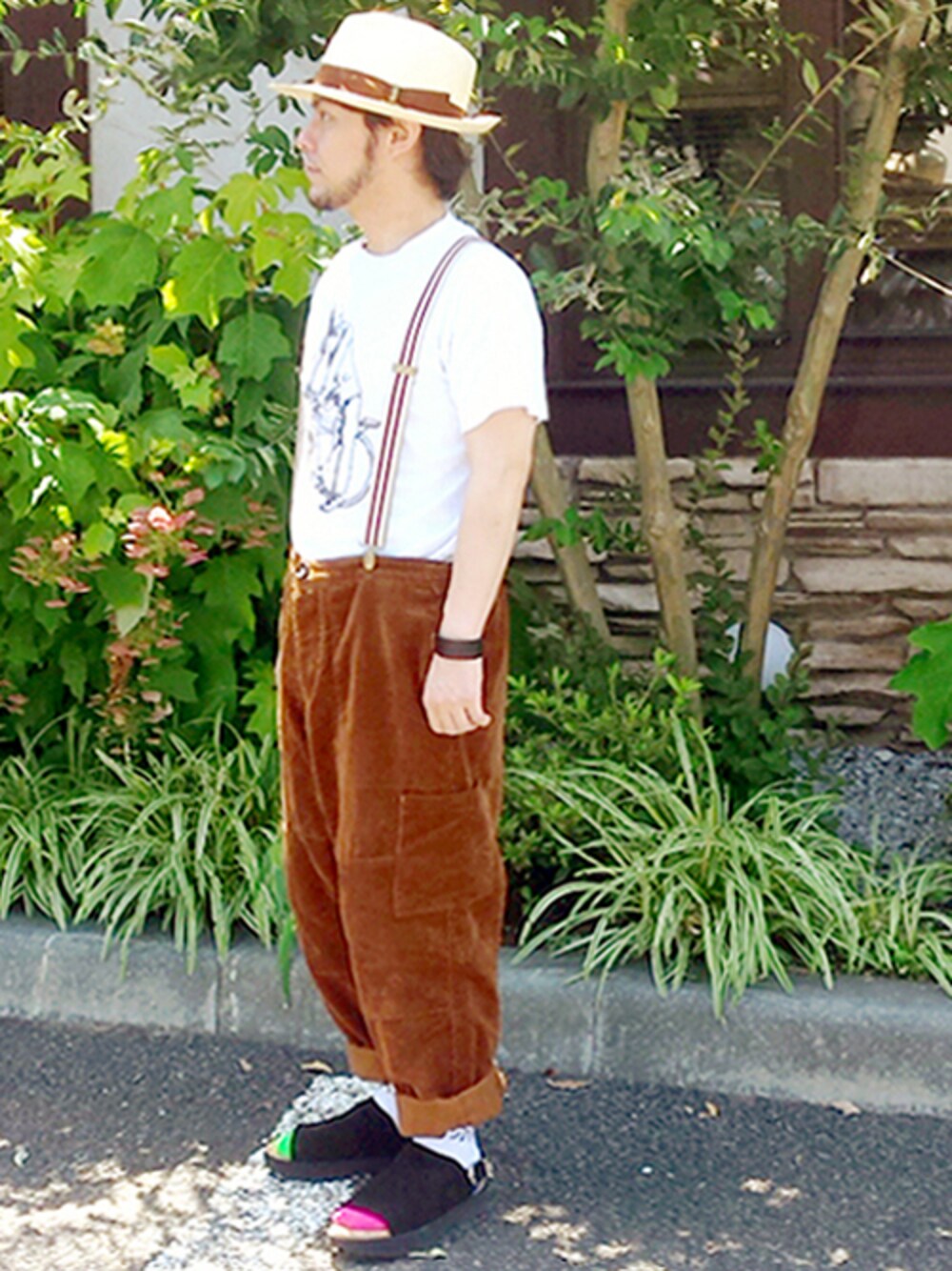 ホワイト系のトップス、イエロー系のチノパンツ、ブラック系のサンダルを着用したメンズの夏コーディネートの1枚目の写真