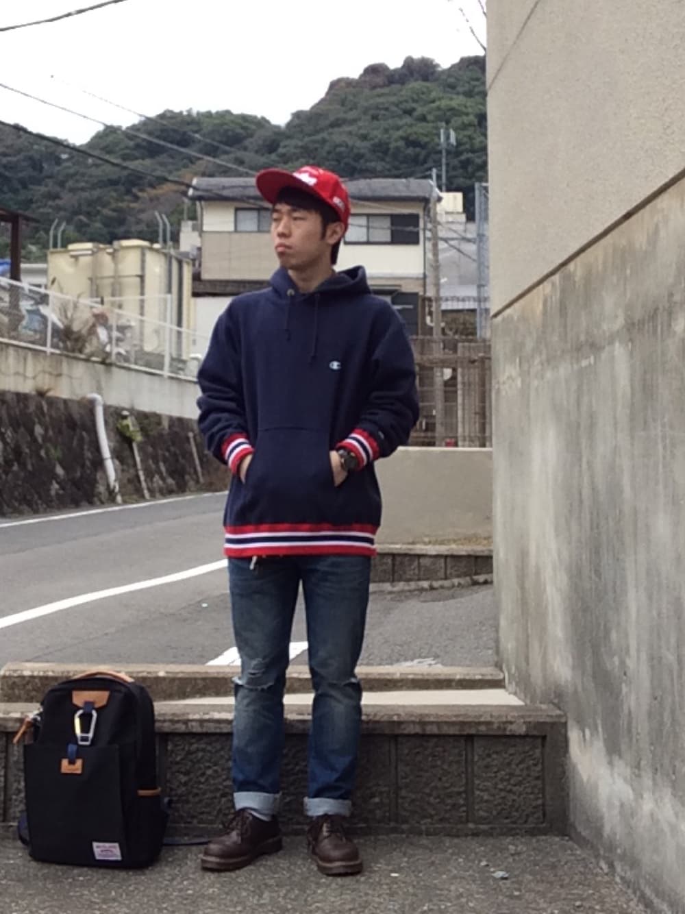 ブルー系のパーカー、レッド系のシャツ/ブラウス、ブルー系のデニムパンツを着用したメンズの冬コーディネートの1枚目の写真