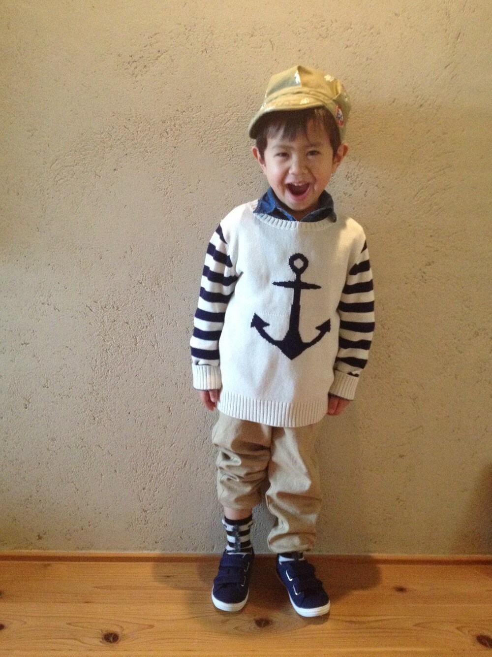 ブルー系のシャツ/ブラウス、ホワイト系のニット/セーター、ベージュ系のチノパンツを着用したキッズの冬コーディネートの1枚目の写真