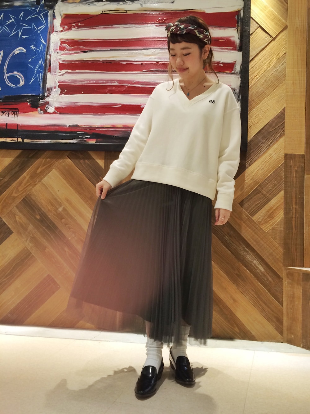 ホワイト系のスウェット、グリーン系のスカート、ブラック系のパンプスを着用したレディースの秋コーディネートの1枚目の写真