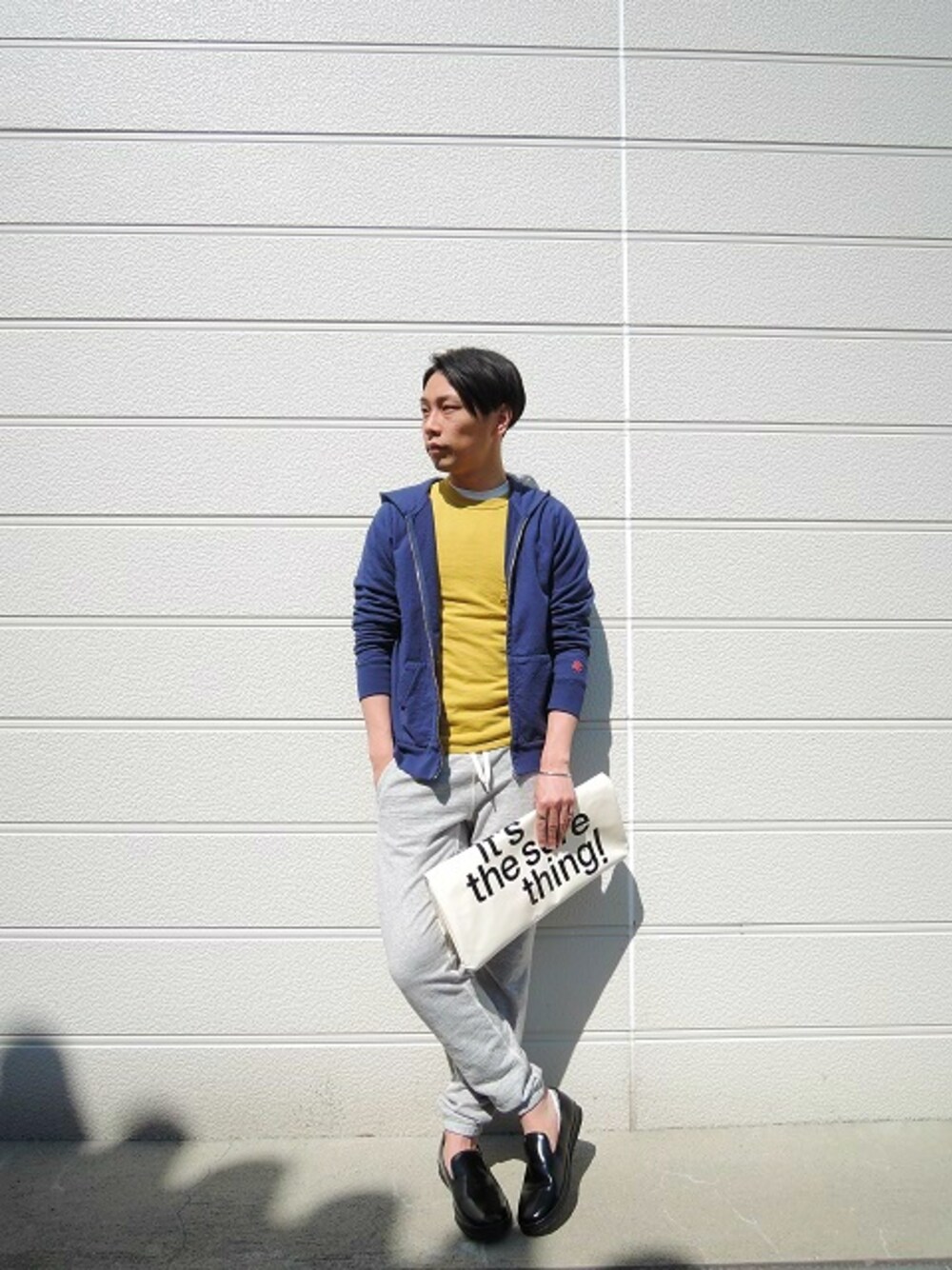 ブルー系のパーカー、イエロー系のTシャツ/カットソー、グレー系のその他パンツを着用したメンズの春コーディネートの1枚目の写真