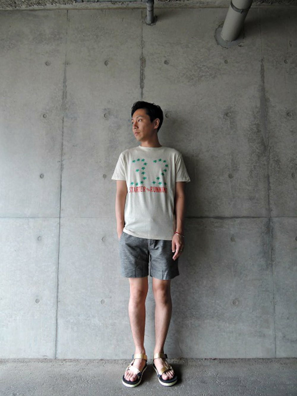 ベージュ系のTシャツ/カットソー、グレー系のその他パンツ、ベージュ系のサンダルを着用したメンズの夏コーディネートの1枚目の写真
