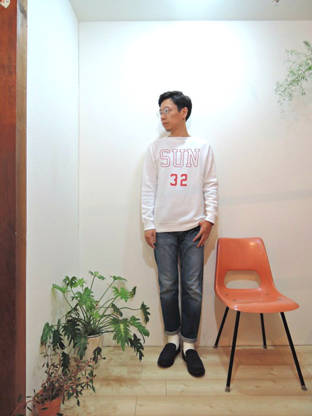 ホワイト系のスウェット、ブルー系のデニムパンツ、ブルー系のブーツを着用したメンズの秋コーディネートの1枚目の写真