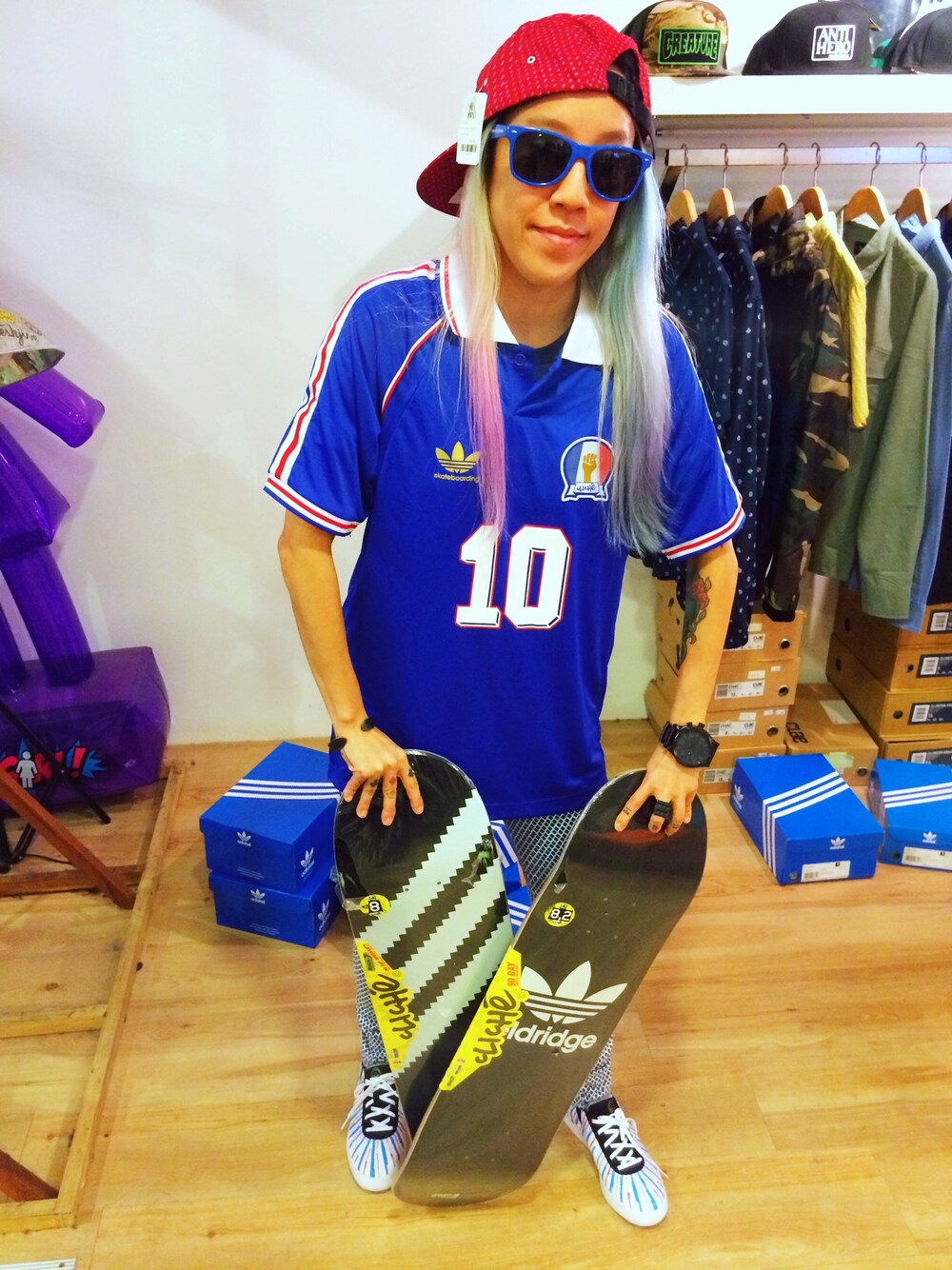 ブルー系のジャージ、ホワイト系のスニーカー、レッド系のキャップを着用したレディースの夏コーディネートの1枚目の写真